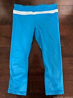 Front view of blue workout pants showing white waistband stripe and overall condition