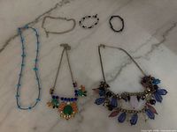 Overview of all six jewelry pieces laid out on marble surface