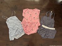 All three women’s pajama sets laid out: striped, pink palm tree print, and grey Victoria’s Secret