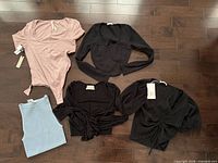 Overview of five women’s tops laid out on floor