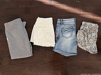 Four folded garments side by side on floor