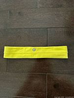 Top view of yellow Lululemon headband showing logo