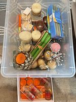 Clear tote showing assortment of pillar, taper, votive/tealight and ball candles in various colours and packaging