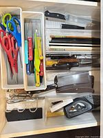 Drawer view showing scissors, paring knives, honing rods, chopsticks, cleaver, sharpener and sheaths