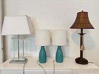 All four lamps lined up side by side on white surface