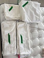 Stacks of white pillowcases and shams on mattress