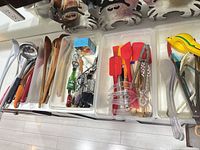 Overview of four trays filled with assorted kitchen utensils showing variety and quantity
