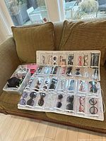 Full view of organizer filled with many pairs of glasses and storage bin containing additional glasses and cases