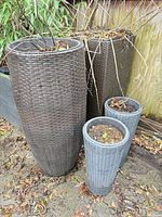 Overall view of two tall and two medium resin wicker-look planters showing size and condition