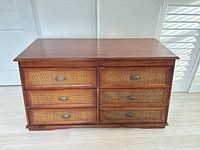 Front view showing six cane-front drawers and cup pulls