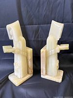 Side view of both marble monk bookends showing L-shaped bases and polished stone