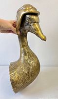 Front profile of brass-finished duck bust with pilot hat