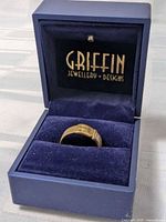 Ring in display box showing belt buckle design