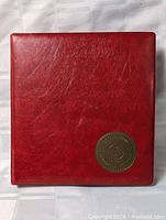 Front cover of red binder with Royal Albums medallion