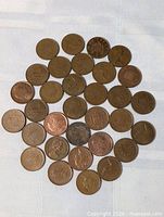 Group of 35 British one-penny coins arranged on cloth