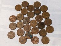 Group view of 28 Canadian 1 Cent coins on fabric background