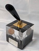 Overall view of resin cube with embedded coins and pen holder