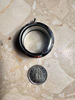 Single locket beside Canadian dime for scale