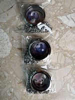 Three stainless steel cat theme lockets with chains in packaging