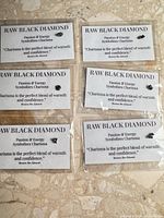 Six individual raw black diamonds on labeled cards