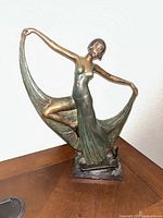 Front view of bronze dancer sculpture on plinth