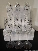 All six silver star champagne flutes grouped in front of white box