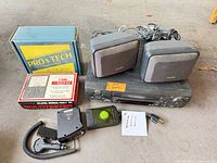 All items grouped: JVC VCR, Aiwa speakers, Micronta multimeter box, Pro-Tech charger box, radar detector with cord, outdoor timer