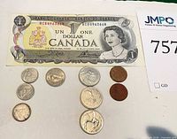 Close-up of 1954 Canadian $1 bill with selection of coins