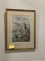 Full view of framed print on wall showing image, mat and gold frame