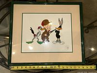 Front view showing sericel artwork, matting, frame and tape measure indicating size