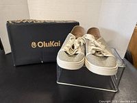 Sneakers displayed with OluKai branded box