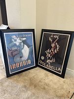 Both framed posters leaning against wall