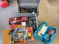 Overview showing Craftsman toolbox, red tray, cardboard box of hand tools, Makita sander case and Blue Point case