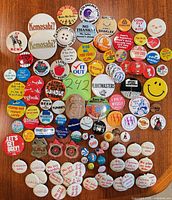 Full group of approximately 75 assorted lapel pins on tabletop