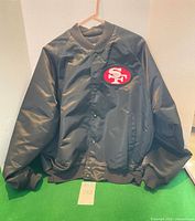 Full view of front of black 49ers bomber jacket