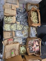 Overview of table with boxes and bags of clock hands, numerals and parts