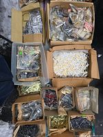 overhead view of multiple boxes filled with assorted clock hands, numerals and parts