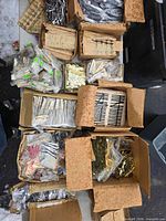 Overview of multiple open boxes filled with bagged clock hands and numerals