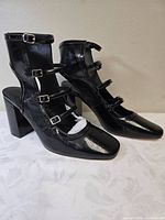 Left side view showing patent finish, block heel and buckle detail