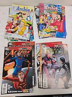 Four stacks showing Archie, Action Comics, Superman: World of New Krypton covers