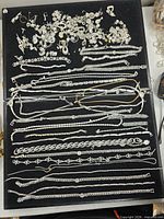 Full tray view of assorted silver-tone jewellery pieces