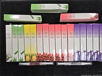 Row of boxed cuticle oil pens assorted scents with two unboxed pens below