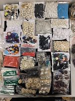 Top-down view of entire lot showing numerous bags of assorted beads
