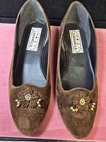 Top view of both brown suede ballet flats showing beaded floral embellishments and overall wear