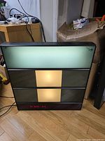 Front view powered on showing illuminated panels and red LED clock