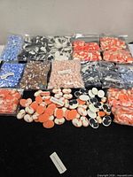 Multiple bags of assorted coloured resin cameos spread on table