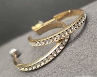 Close-up of both 14K gold hoop earrings showing clear stones along edge