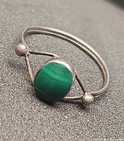Angle view showing green cabochon stone and band design
