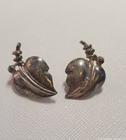 Front view showing leaf motif and spiral stem on both earrings