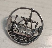 front view of sterling silver brooch showing Viking ship motif